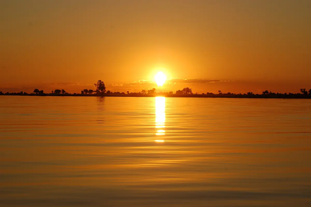 The sun setting over the Chobe River with its golden reflection